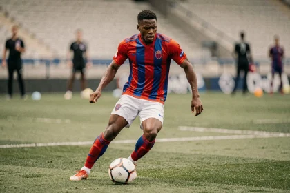 Joueur de football du PSG en action lors d'un entraînement, illustrant la lutte pour une place de titulaire indiscutable