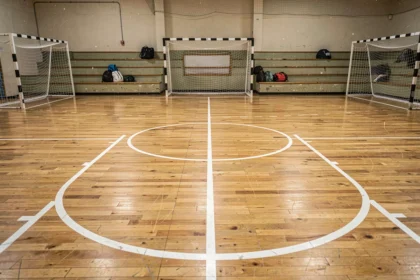 Vue complète d'un terrain de handball pour club amateur dans une salle polyvalente avec marquages au sol et buts réglementaires